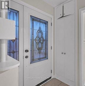 Toronto (Wexford-Maryvale) apartment for rent - A white door with a stained glass window and a white cabinet to the right.