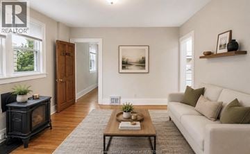 Windsor apartment for rent - A living room with a white couch, a black fireplace, and a painting on the wall.