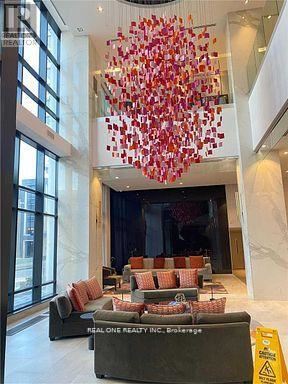 Toronto (Islington-City Centre West) condo for rent - A large chandelier with red and white decorations hangs from the ceiling in a spacious room.