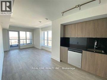 Toronto (Islington-City Centre West) condo for rent - A spacious kitchen with wooden cabinets and a black countertop.