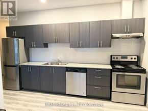 Waterloo condo for rent - A modern kitchen with dark grey cabinets and stainless steel appliances.