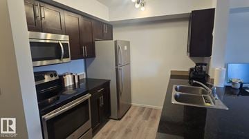 Edmonton apartment for rent - A modern kitchen with dark wood cabinets and stainless steel appliances.