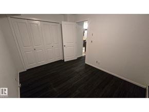Edmonton apartment for rent - A hallway with white doors and dark wood flooring.
