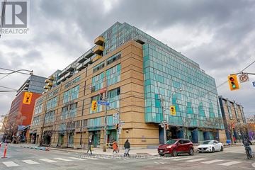 Toronto (Waterfront Communities) condo for rent - A modern building with a glass facade is the focal point of the image.