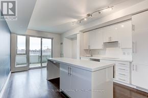 Toronto (Waterfront Communities) condo for rent - A kitchen with white cabinets and a large island.