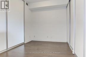 Toronto (Waterfront Communities) condo for rent - A room with white walls and wooden flooring, with a door on the left side.
