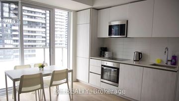 Toronto (Waterfront Communities) condo for rent - A modern kitchen with a dining table and chairs.