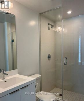 Toronto (Waterfront Communities) condo for rent - A white bathroom with a glass shower stall and a white sink.