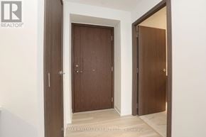 Toronto (Waterfront Communities) condo for rent - A brokerage sign is on the bottom left of a hallway with two doors.