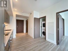 Toronto (Waterfront Communities) condo for rent - A modern kitchen with wooden floors and white walls.