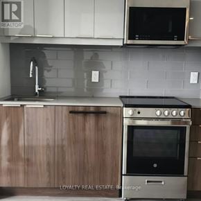 Toronto (Birchcliffe-Cliffside) condo for rent - A kitchen with a stove and a microwave above it.
