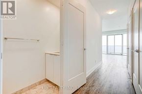 Toronto (Mimico) condo for rent - A white hallway with a door on the left and a window on the right.
