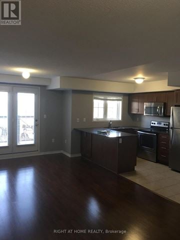 Oakville (Ro River Oaks) townhouse for rent - A kitchen with dark wood floors and stainless steel appliances.