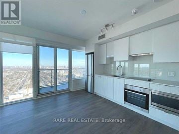 Toronto (Mount Pleasant West) condo for rent - A spacious kitchen with white cabinets and a view of the city.