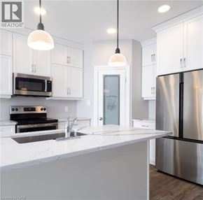 North Perth townhouse for rent - A modern kitchen with white cabinets and a stainless steel refrigerator.