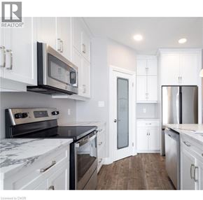 North Perth townhouse for rent - A kitchen with white cabinets and a marble countertop.