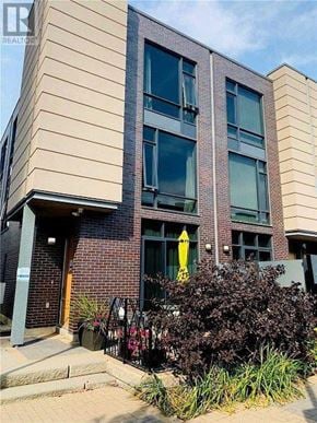 Toronto (Islington-City Centre West) townhouse for rent - A modern building with a brick facade and a yellow flag on the door.