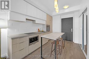 Toronto (Mount Pleasant West) condo for rent - A modern kitchen with white cabinets and a wooden island.