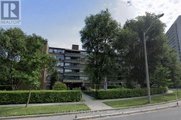 Toronto (Thorncliffe Park) condo for rent - A street view of a residential area with apartment buildings and greenery.