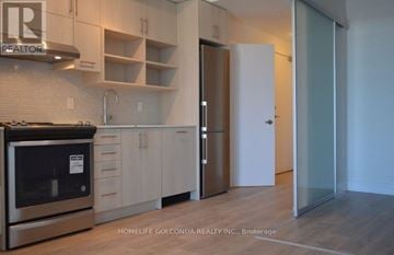 Toronto (Don Valley Village) condo for rent - A modern kitchen with a stainless steel oven and white cabinets.