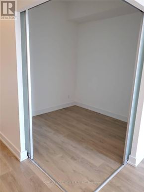 Toronto (Don Valley Village) condo for rent - A room with a wooden floor and white walls, with a doorway open to another room.