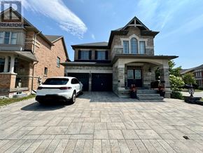 Markham (Berczy) apartment for rent - A white car is parked in front of a two-story house.