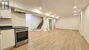 Mississauga (Malton) apartment for rent - A spacious room with wooden flooring and a staircase in the background.
