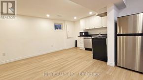 Mississauga (Malton) apartment for rent - A kitchen with stainless steel appliances and wooden flooring.
