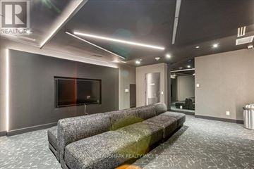 Toronto (South Parkdale) condo for rent - A modern living room with grey couches and a flat screen TV.
