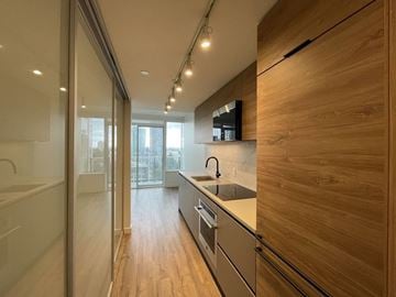 Surrey apartment for rent - A modern kitchen with wooden cabinets and a glass door.