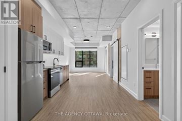 Ottawa condo for rent - A modern kitchen with wooden floors and stainless steel appliances.