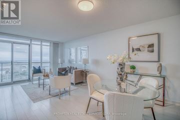 Toronto (Waterfront Communities) condo for rent - A well-lit, modern living room with a glass table and white chairs.