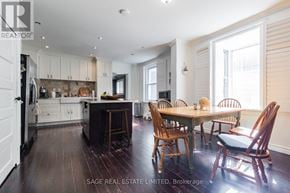 Toronto (Greenwood-Coxwell) apartment for rent - A well-lit kitchen with wooden floors and furniture.