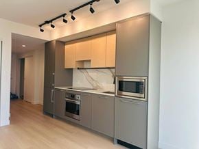 Surrey apartment for rent - A modern kitchen with stainless steel appliances and wooden cabinets.
