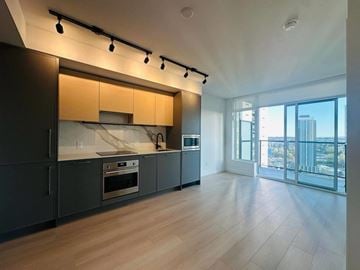 Surrey apartment for rent - A modern kitchen with wooden cabinets and a large window overlooking the city.