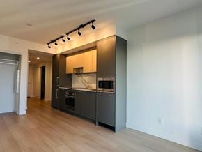 Surrey apartment for rent - A modern kitchen with wooden floors and stainless steel appliances.