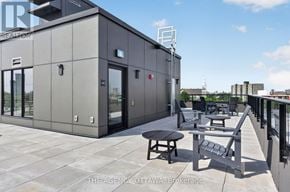 Ottawa condo for rent - A grey building with a table and chairs on a patio.