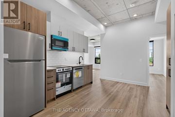 Ottawa condo for rent - A modern kitchen with a stainless steel refrigerator and wooden cabinets.