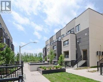 Burlington (Lasalle) townhouse for rent - A modern apartment complex with a landscaped courtyard in the foreground.