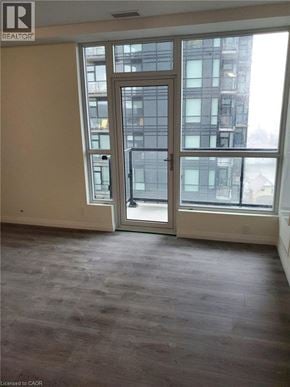Kitchener condo for rent - A room with a large window and a sliding glass door.