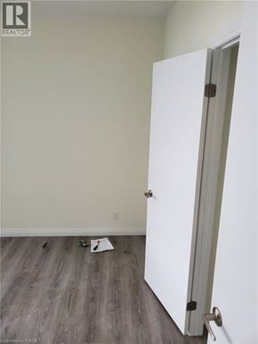 Kitchener condo for rent - A white door is open in a room with wood flooring.