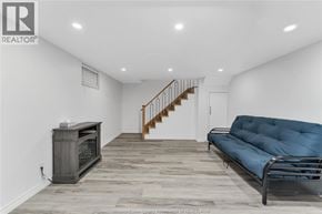 Windsor apartment for rent - A living room with a blue couch and a wooden floor.