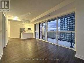 Mississauga (Hurontario) condo for rent - A spacious room with a desk and a large window overlooking a cityscape.