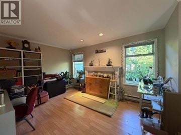 Burnaby townhouse for rent - A living room with a fireplace and a dining area.