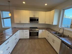 Edmonton apartment for rent - A kitchen with white cabinets and a granite countertop.