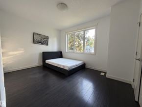 Edmonton apartment for rent - A bedroom with a bed, a window, and a picture on the wall.