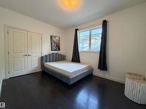 Edmonton apartment for rent - A bedroom with a bed, a radiator, and a window with curtains.