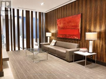 Toronto (Church-Yonge Corridor) condo for rent - A modern living room with a brown couch, a glass table, and a red abstract painting on the wall.
