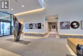 Richmond Hill (South Richvale) condo for rent - A reception area of Anjia Realty, Brokerage with a stone sculpture on the left and framed pictures on the wall.