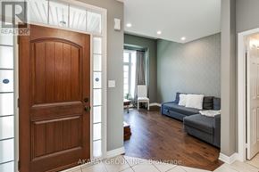 Burlington (Alton) apartment for rent - A brokerage logo is on the door of a well-lit room with a grey couch.